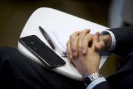 hands clasped with phone beside