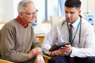 doctor shows older man ipad