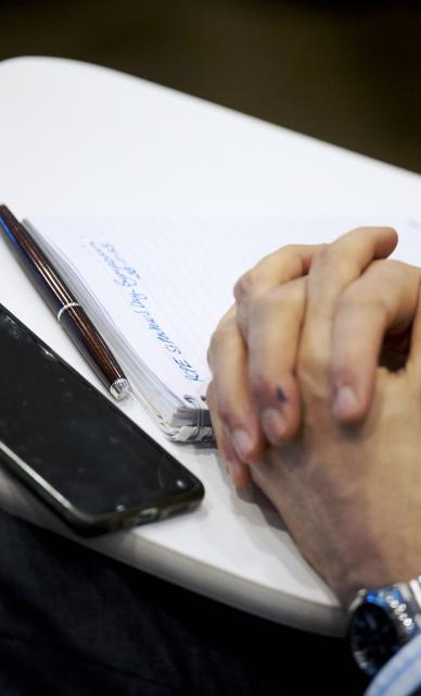 hands clasped with phone beside