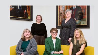 exam team posing on yellow sofa