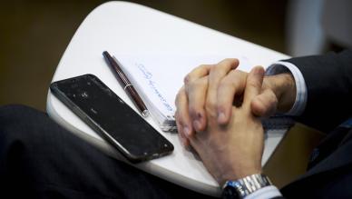 hands clasped with phone beside