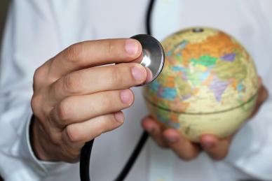 Doctor holding globe with stethoscope
