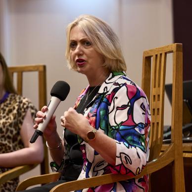 women sitting speaking to microphone